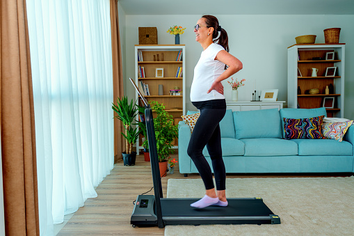 Pregnant Woman Walks on a Treadmill and Uses a Tablet at Home, healthy pregnancy.