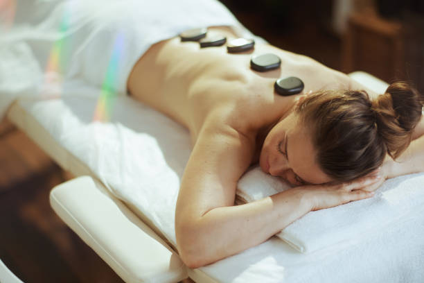woman having hot stone massage and laying on massage table