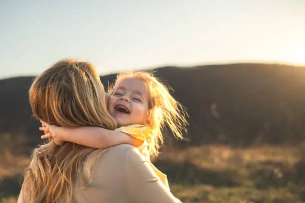 Happy girl kid hugging mom in the nature Happy girl kid hugging mom in the nature