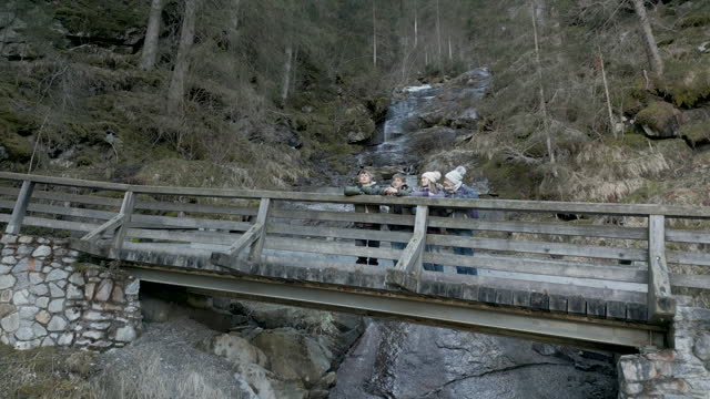 Drove view aerial footage of family hiking in Austrian Alps