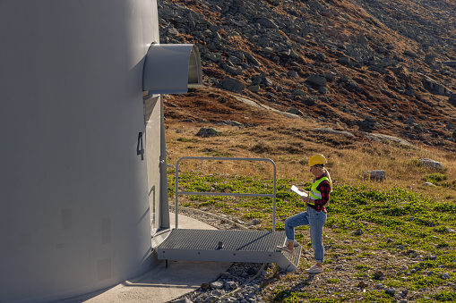 Renewable technologies for wind infrastructure ti produce renewable energy in nature. Engineer conducting an inspection