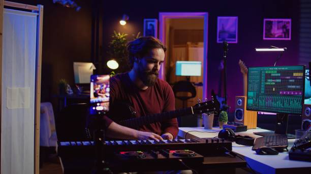 istock Musical producer doing online guitar lessons with smartphone vlog 2075414371