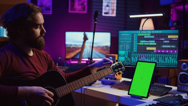 istock Audio engineer practices tuning his acoustic guitar in home studio 2075418610