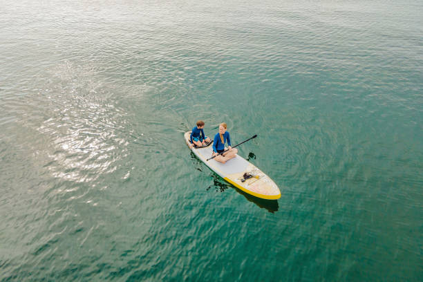 istock Mother and son paddling on stand up board having fun during summer beach vacation 2075419736