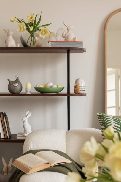 istock Sunny and design interior of living room with easter decorations, tulips, modular sofa, shelf, pillows and elegant accessories. Home decor. Easter holidays. 2075428654