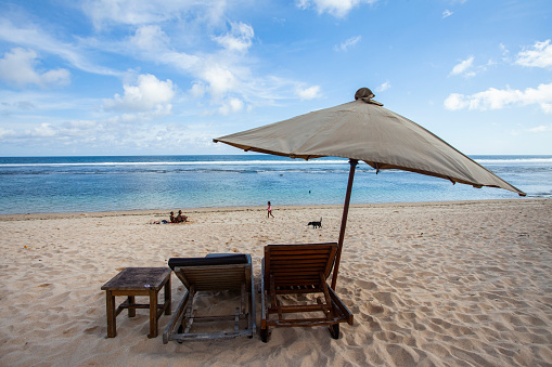 Umbrellas and lounge chairs are provided for tourists to enjoy the beauty of Melasti Beach in Bali, Indonesia. Melasti Beach is one of the favorite destinations in Bali.