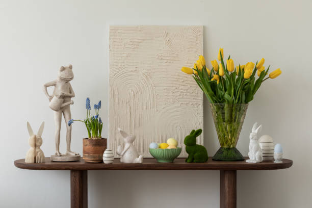 istock Spring and easter composition of living room interior with mock up poster frame, pouf, flowers, tulips, easter decorations and elegant accessories. Template. 2075434632