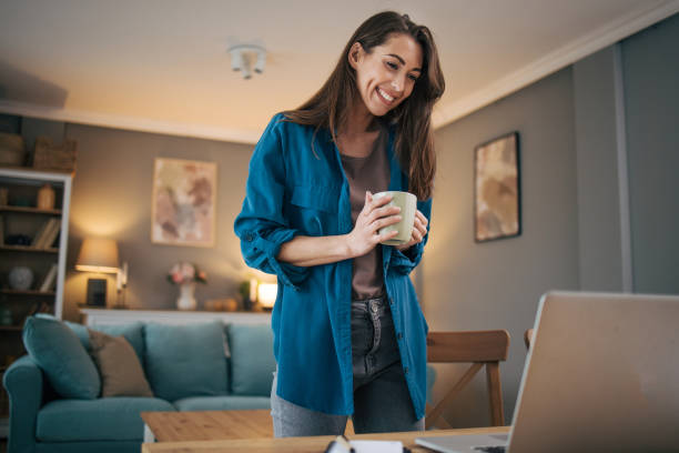 istock Beautiful attractive woman using laptop and drinking coffee. 2075445404