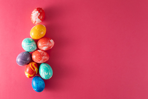 Hand colored colorful easter eggs on pink background