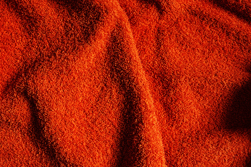 Texture of orange bath towel, top view