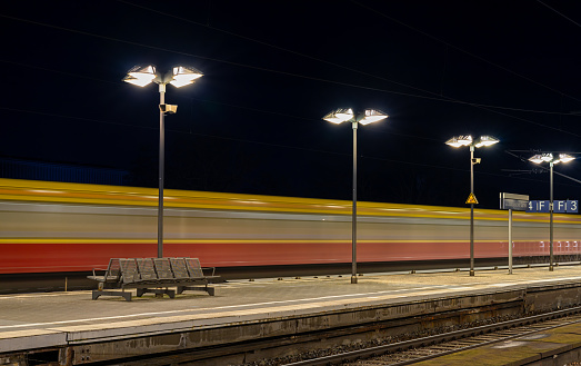 Germany, Berlin - February 28, 2024 - Blurred motion of passenger train leaving railroad station at night, Berlin Charlottenburg