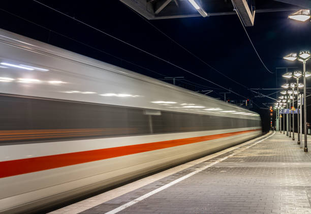 Germany, Berlin - February 28, 2024 -Blurred motion of passenger train leaving railroad station at night, Berlin Charlottenburg