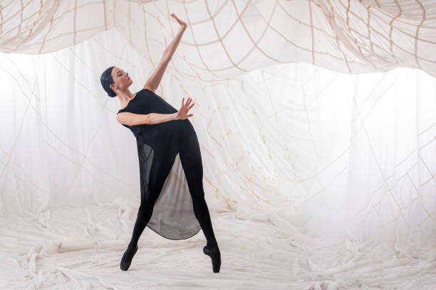 ballerina dancer in a black suit dances on a white background - chiton zdjęcia i obrazy z banku zdjęć