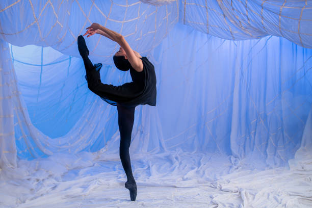 ballerina dancer in a black suit dances on a blue background - chiton zdjęcia i obrazy z banku zdjęć