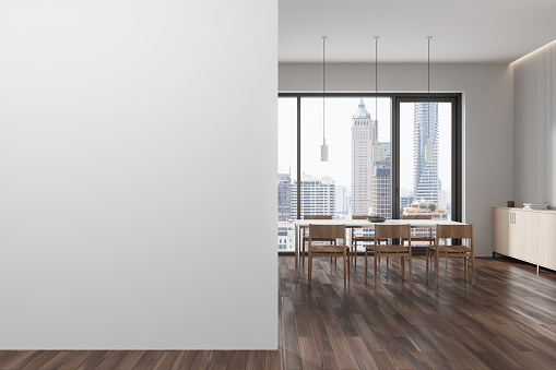 White home living room interior with dining table, chairs on hardwood floor. Stylish meeting or eating place with panoramic window on skyscrapers. Mockup copy space empty wall partition. 3D rendering