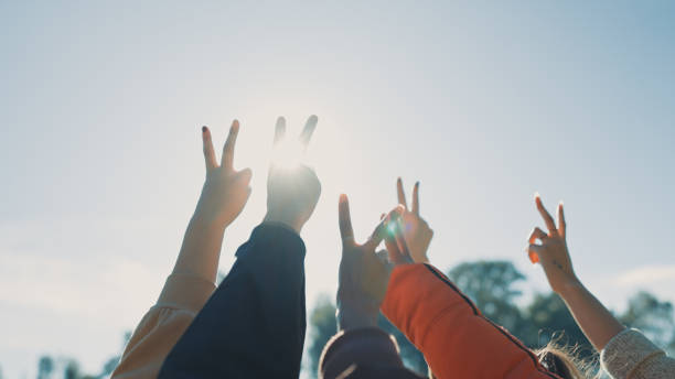 freiwillige, freunde und hände mit peace-zeichen im freien mit unterstützung, gemeinschaft oder solidarität. freiwilligenarbeit, menschenmenge oder menschen mit v-emoji in der natur für wohltätige zwecke, dienst oder hilfe, aktivismus und hoffnung im - friedenssymbol stock-fotos und bilder