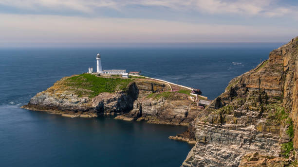 istock South Stack lighthouse, on Anglesey, north Wales. The lighthouse is located on a small island just off the mainland and is reached by a flight of very steep stairs. It is a bright summers day 2075517181