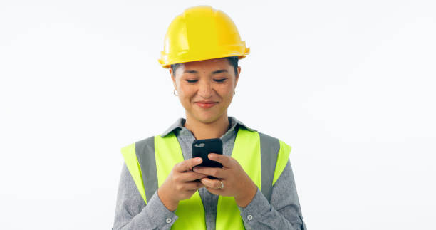 istock Engineering, woman and phone for construction chat, communication and project management in studio. Asian contractor or builder typing on mobile for architecture design update on a white background 2075543387