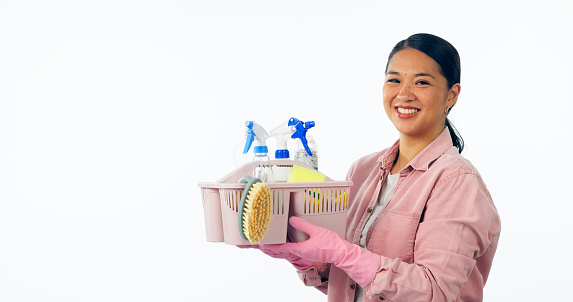 Woman, portrait and cleaning supplies in studio smile for housework, service or hygiene. Asian person, face and container for disinfection product white background or liquid spray, chemical as mockup