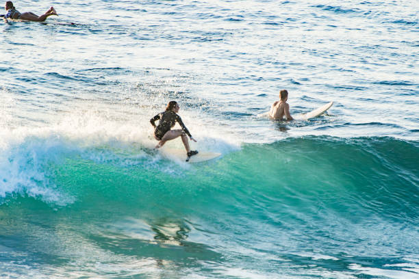Manhattan Beach, California - June 19, 2023 - Image capturing candid, high-energy surfing action in dynamic coastal settings, highlighting surfers' athletic skill, surf culture, and the vibrant energy of the ocean and beach lifestyle.