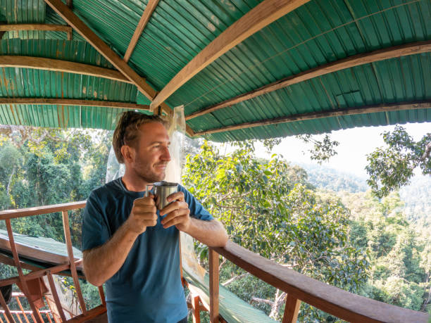 istock One man enjoying nature from a tree house in the morning 2075556404