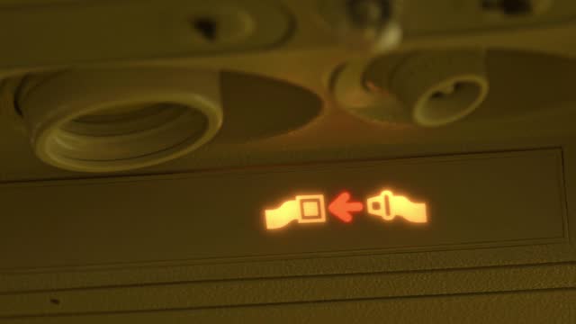 Airplane Safety Sign Light Showing Passengers To Fasten Their Seatbelts