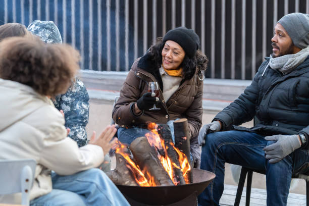 istock Cheerful family sitting around a fire in winter 2075566401
