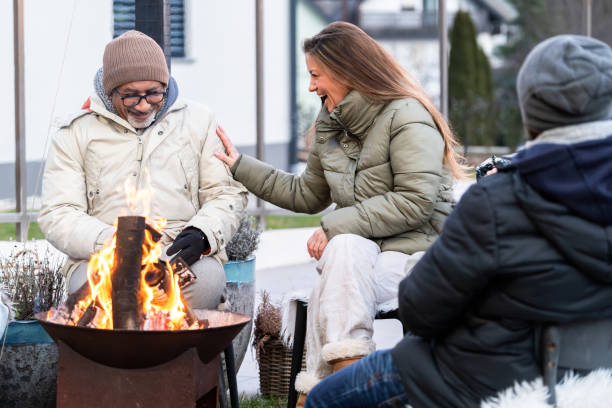 istock Cheerful family sitting around a fire in winter 2075566404