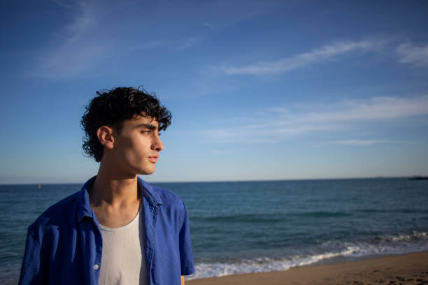 istock Portrait of young man on the beach 2075569578