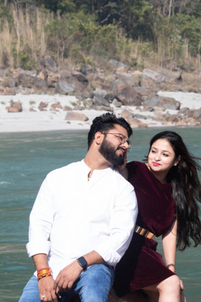 istock Love and laughter intertwine by the Ganges in Rishikesh as she playfully pulls at his ear on a riverside rock 2075572217