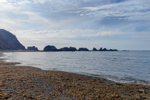 istock a serene beach with rocky formations, calm waters, and a cloudy sky creating a peaceful atmosphere 2075580083