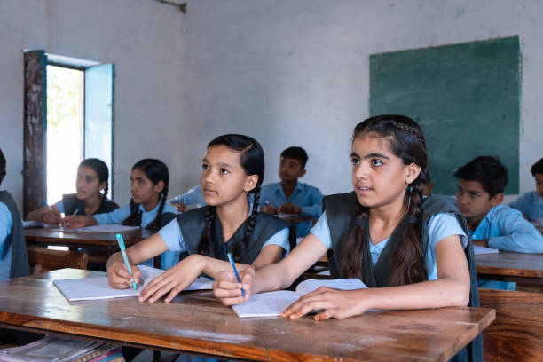 istock Group of indian village students in school uniform sitting in classroom doing homework, studying. Education concept 2075583061