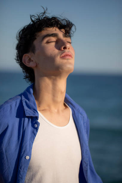 istock Portrait of young man on the beach 2075584790