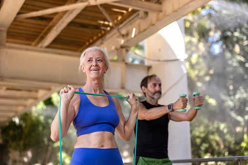 older couple doing sports and stretching with elastic bands