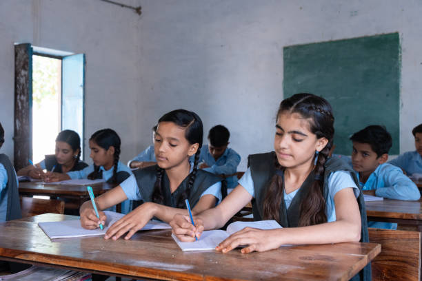 istock Group of indian village students in school uniform sitting in classroom doing homework, studying. Education concept 2075586344