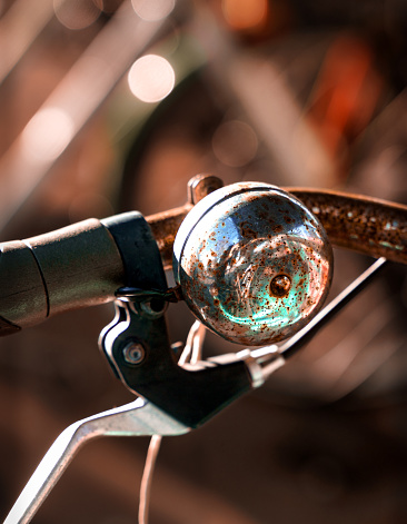 A close-up of a bicycle bell with a soft focus background