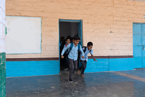 Group indian rural children in school uniform running in school corridor. Education concept