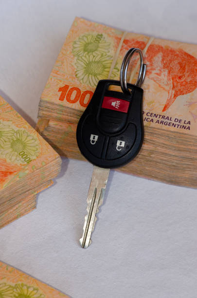 istock car key with bills around it, Argentine pesos as a car purchase concept 2075596586