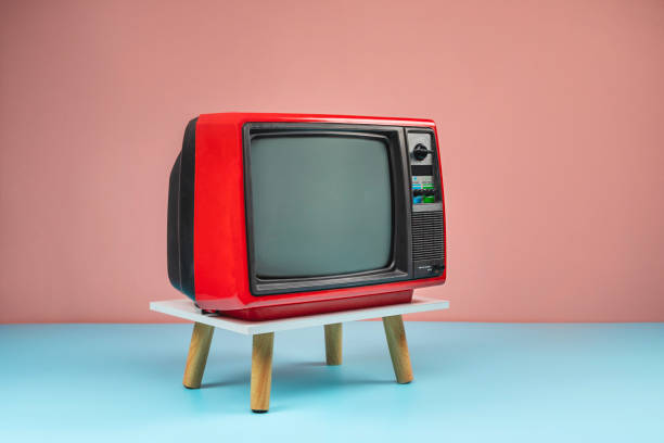 istock Retro red old television on a stand with blank screen with copy space, colorful vintage analog TV with pink wall background. 2075604736
