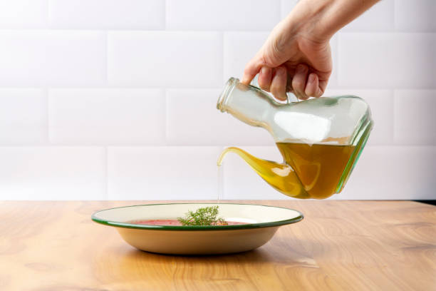 istock Hand pouring olive oil onto a Mediterranean diet plate 2075654742
