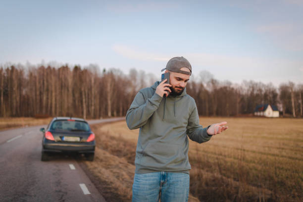 istock Stressed man calling for help while being stranded on the side of the road 2075689810
