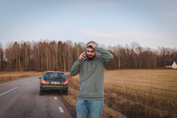 Stressed man calling for help while being stranded on the side of the road