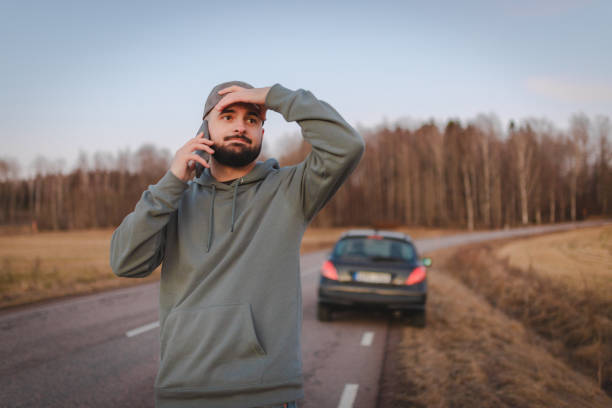 istock Stressed man calling for help while being stranded on the side of the road 2075690339