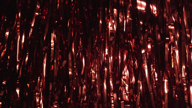 Background of red tinsel with iridescent light. Party concept