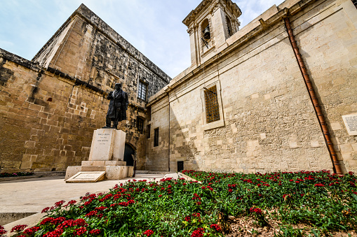 Flower Garden Next To Sir Pawlu Boffa Statue, Former Prime Minister of Malta in Valetta, Malta. Statue of Paul Boffa in Castille Square, Valletta, sculpted by Vincent Apap in 1976.