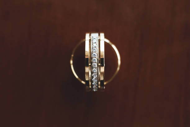 Five and single stone diamond rings on the red velvet,at the wooden surface with red dry roses.
