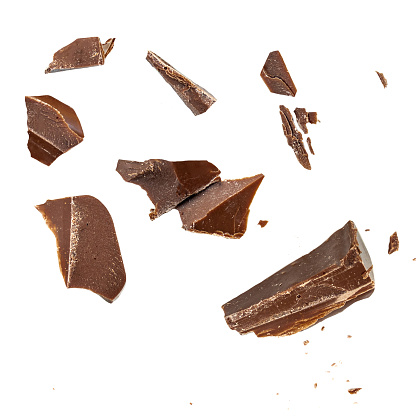 Chocolate broken into pieces in the air isolated on a white background. Milk dark  chocolate explosion, pieces shattering on white background close up