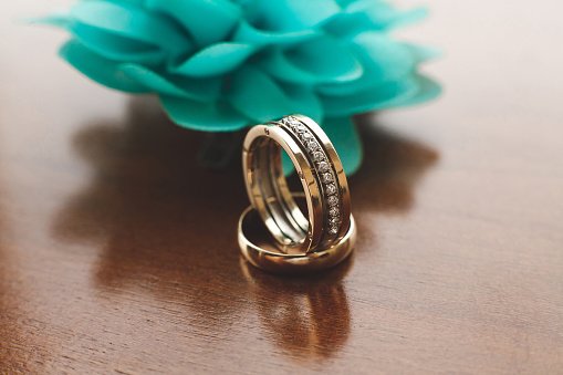 Wedding rings on wooden background.