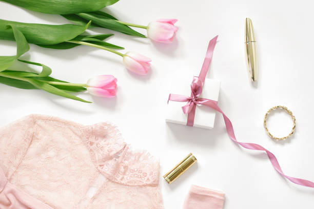 ピンクのチューリップの花束、ピンクのリボンが付いたギフトボックス、ブラウス、化粧品。バレンタインデー、母の日、誕生日、ブロガーの春のコンセプト