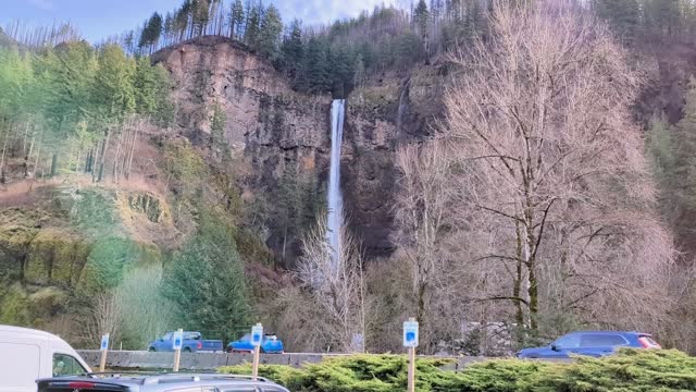 Tourists are enjoying a up-close view of roaring Multnomah Falls from Multnomah Creek Bridge.
